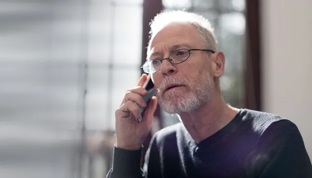 older man talking on phone